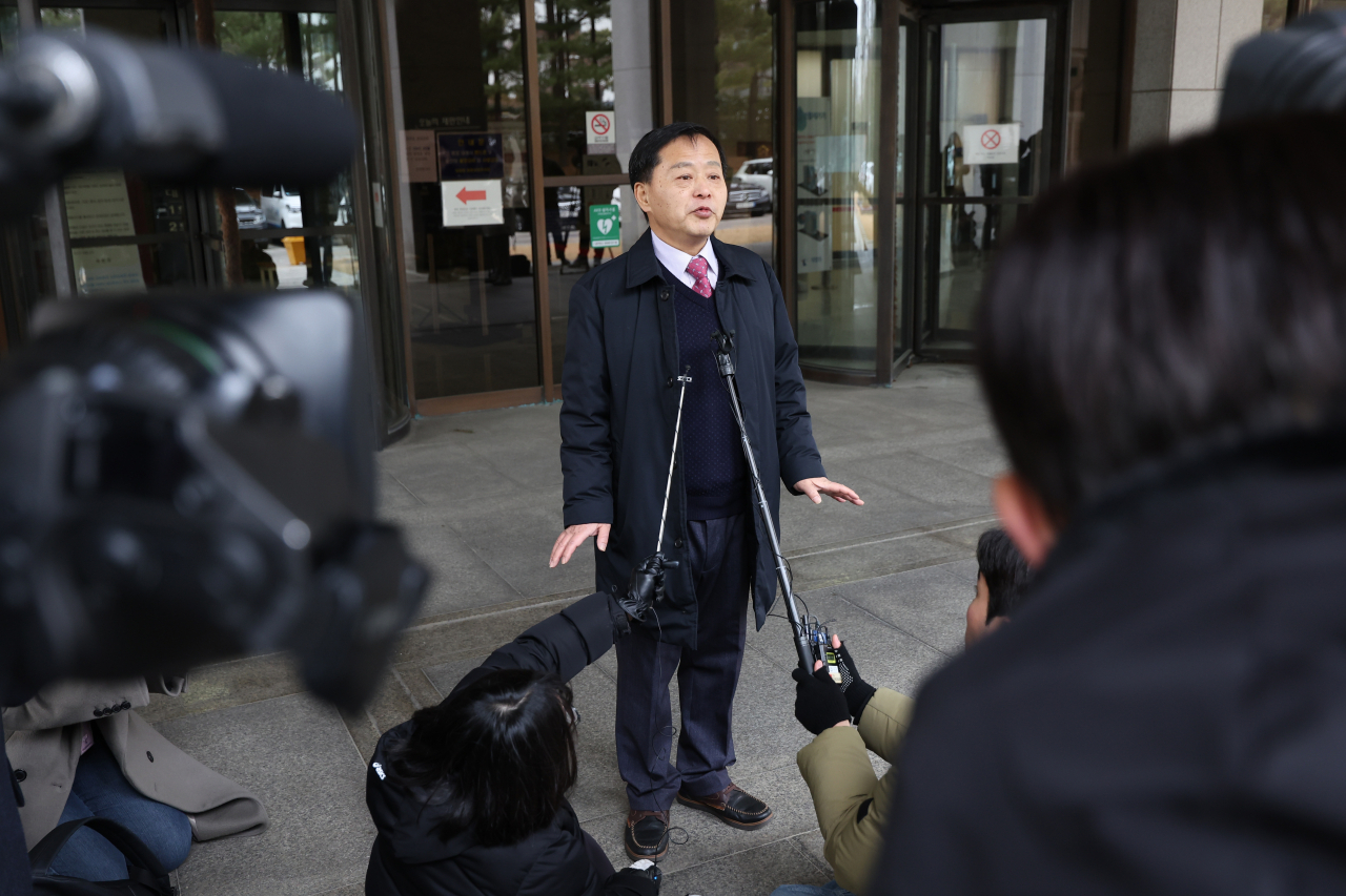 Koo Bon-chang, người điều hành trang web Bad Fathers, trả lời câu hỏi của một nhóm phóng viên trước Tòa án Tối cao ở Seoul. Ảnh: Yonhap