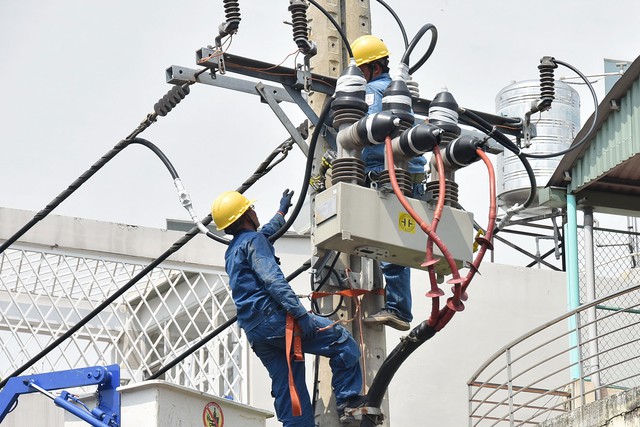 Nhân viên Tổng Công ty Điện lực TP HCM kiểm tra hệ thống tải điện Ảnh: TẤN THẠNH