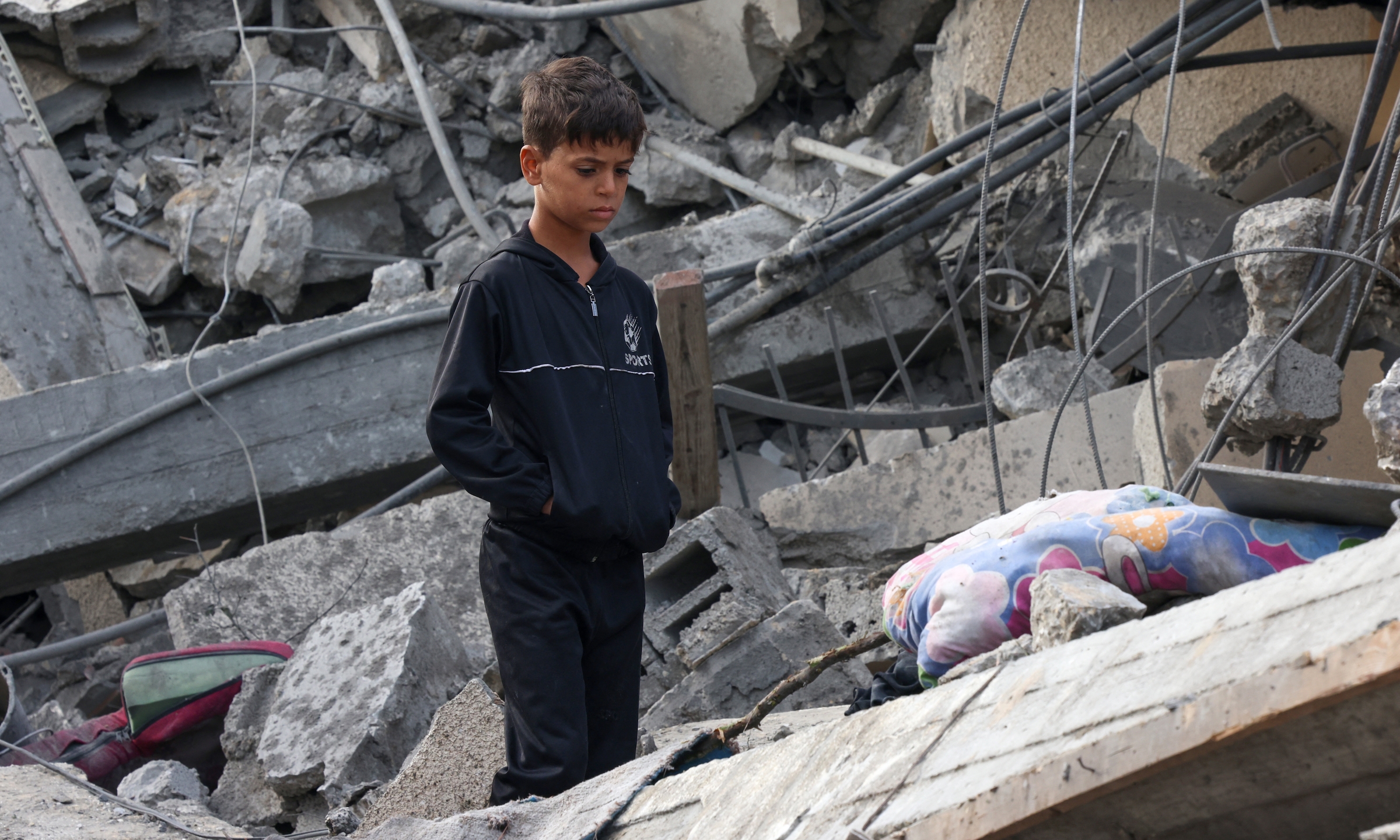 Em nhỏ đứng giữa đống đổ nát của một tòa nhà bị Israel không kích ở Rafah, phía nam Dải Gaza, ngày 22/11. Ảnh: AFP