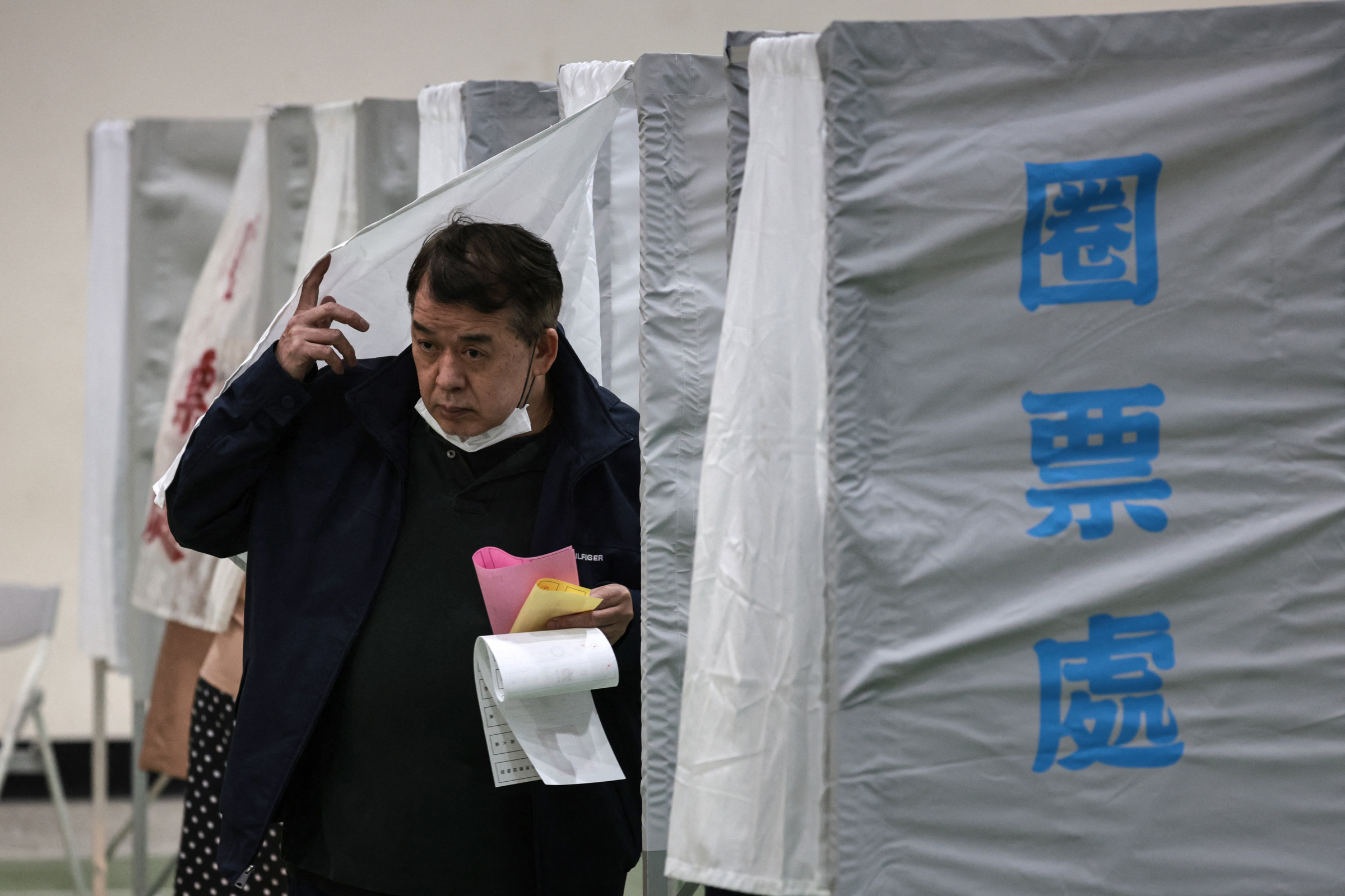 Cử tri Đài Loan rời đi sau khi hoàn tất bỏ phiếu tại điểm bầu cử ở thành phố Đài Nam ngày 13/1. Ảnh: AFP