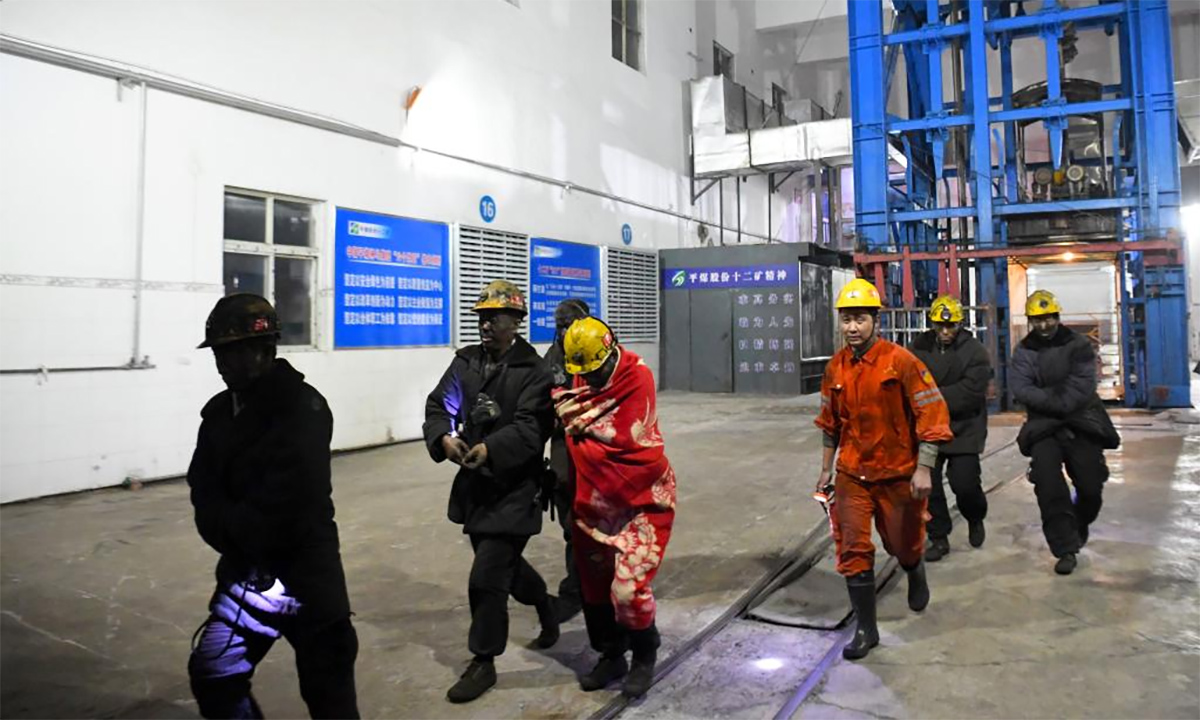 Nhân viên cứu hộ Trung Quốc (áo cam) cùng các thợ mỏ được giải cứu sau vụ tai nạn ở tỉnh Hà Nam ngày 12/1. Ảnh: Xinhua