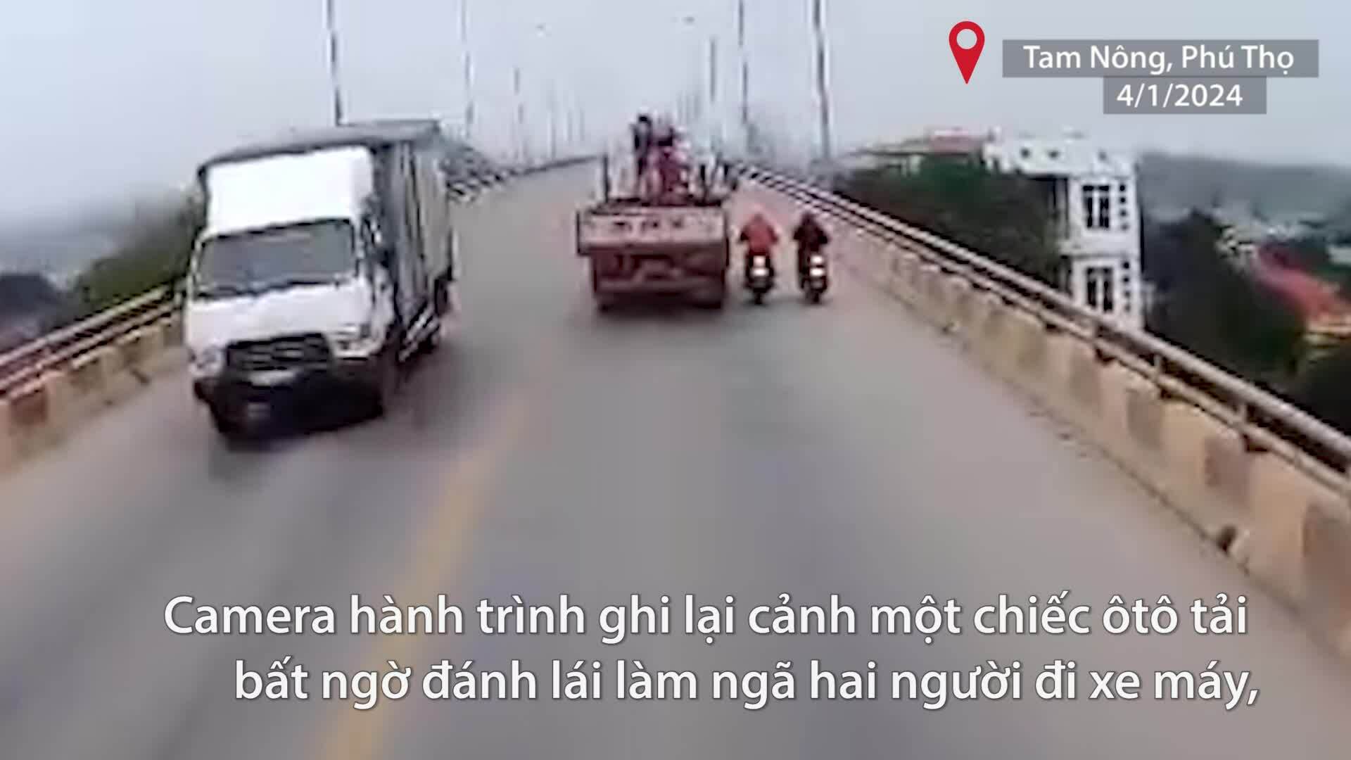 Tài xế xe tải đánh lái làm 2 người đi xe máy ngã ra đường