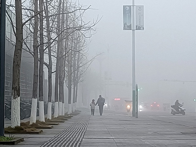 Người dân đi bộ trong sương mù dày đặc ở TP Quảng An, tỉnh Tứ Xuyên, sáng 4-1. Ảnh: The Paper